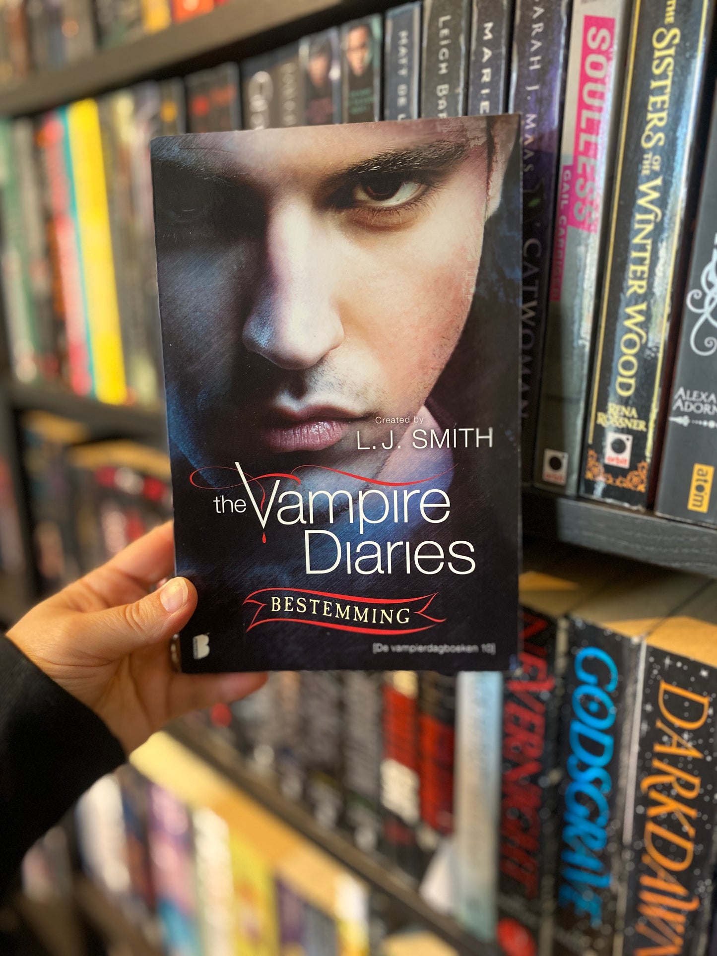 Hand die het boek Bestemming van L.J. Smith vasthoudt, deel 10 in The Vampire Diaries serie.